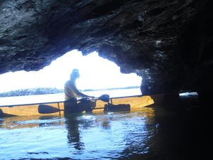 looking out from Aegean Lake water cave at solo canoer